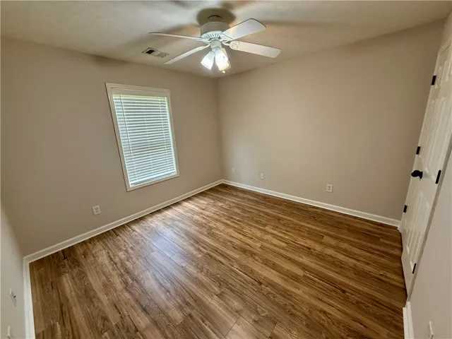 This inviting bedroom features rich hardwood flooring and abundant natural light, creating a bright and airy retreat.