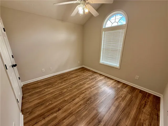 This spacious room features vaulted ceilings and rich wood flooring.