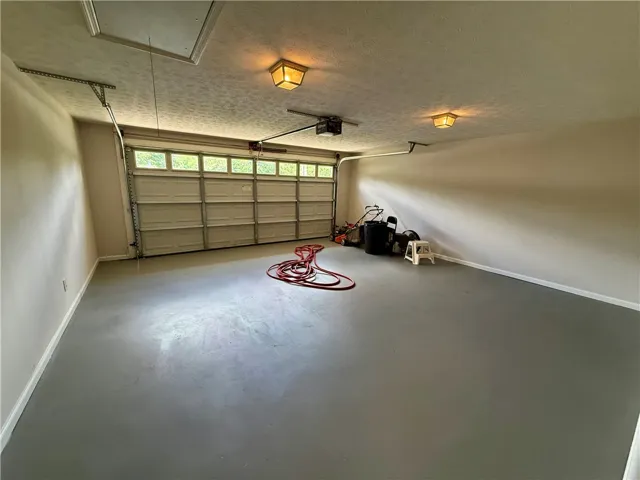 This spacious garage offers ample room for vehicles and storage, featuring a durable concrete floor.