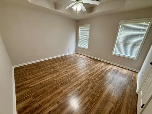 This inviting bedroom features rich hardwood flooring and abundant natural light.