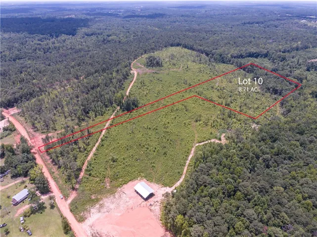 Generous acreage with mature trees and a cleared area offers potential for a private estate.