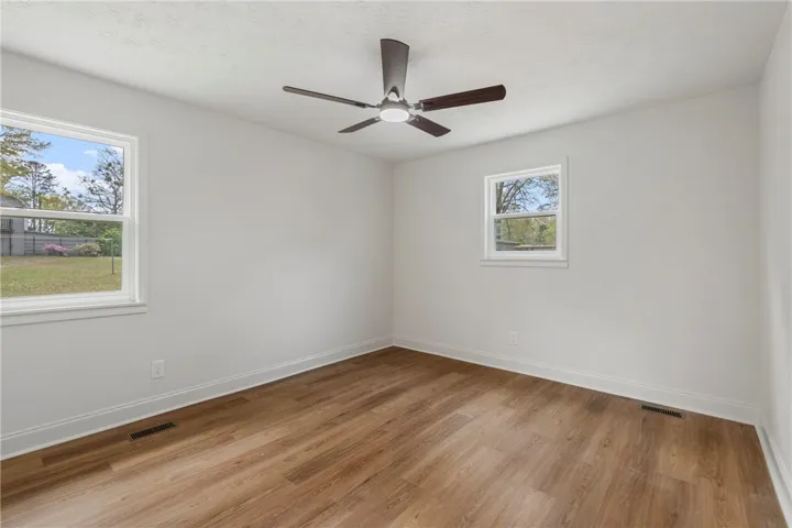 Bright and airy room with durable wood flooring and ample natural light.