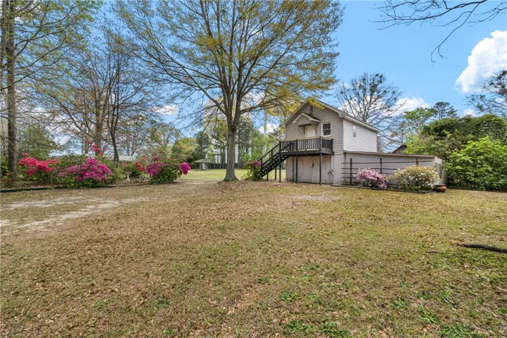 This charming property offers a private yard and a detached structure, surrounded by lush landscaping.