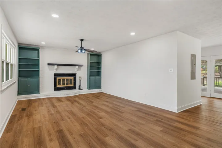 This inviting living space features warm flooring, built-in shelving, and a cozy fireplace.