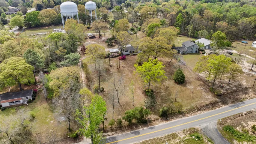 An aerial perspective reveals a vast landscape with mature trees and a tranquil residential setting.