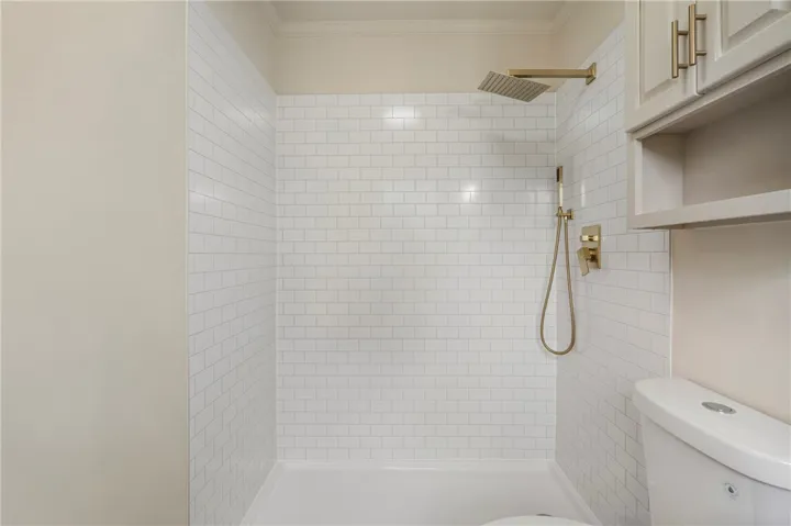This bathroom features a contemporary shower with subway tile, offering a crisp, clean aesthetic.