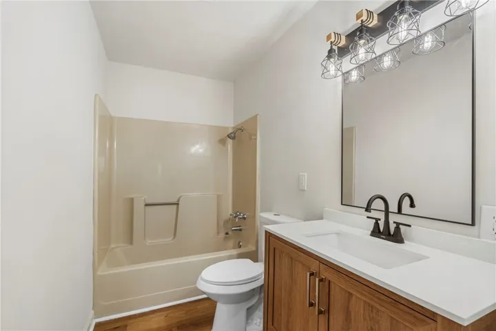 This clean bathroom features a modern vanity and an inviting shower-tub combination.