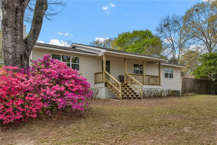 This charming home offers a welcoming facade with vibrant landscaping.