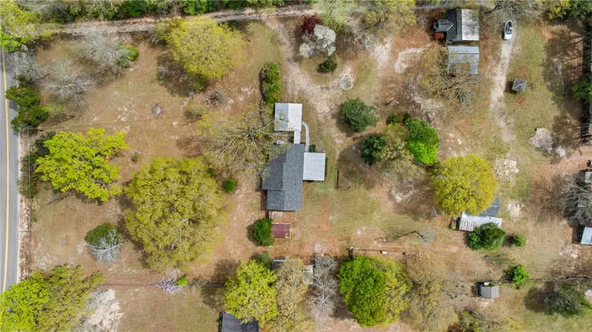 This bird's-eye view showcases a home nestled amidst lush green and mature trees.