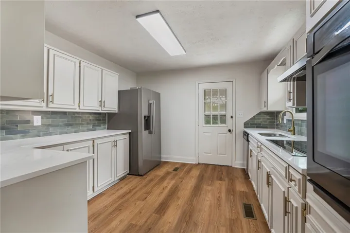 This bright kitchen features durable flooring and contemporary finishes, perfect for daily living and entertaining.