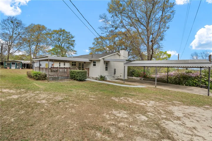 This charming residence features a spacious deck and convenient carport, offering comfortable outdoor living and parking.