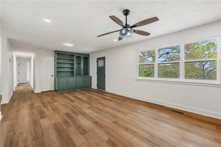 This bright living area features built-in shelving, rich flooring, and ample natural light.
