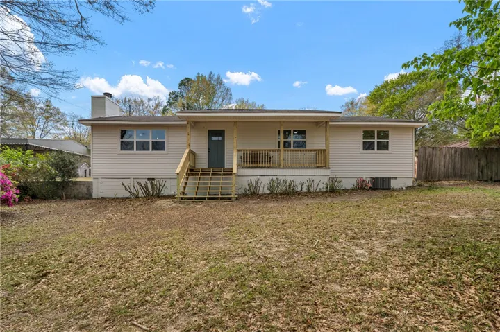 This charming home offers a welcoming facade with a cozy front porch and ample outdoor space.