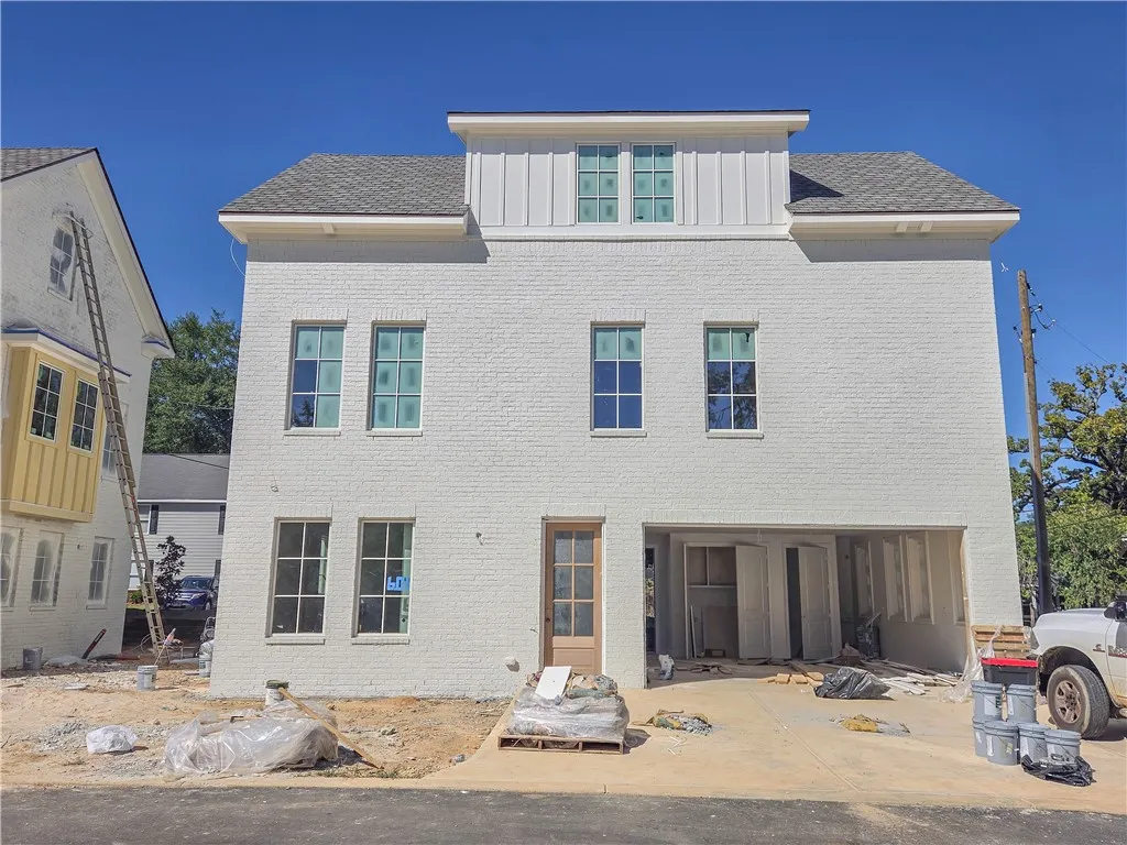 Multi-story brick home architecture pairs clean lines with a classic shingled roofline.