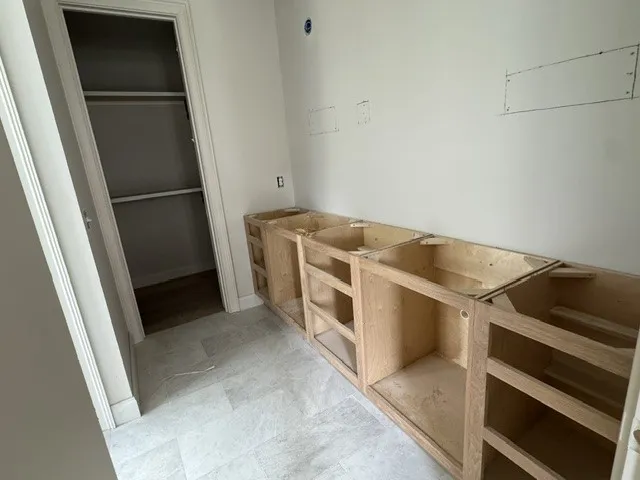 Tiled flooring runs throughout this versatile utility room under construction.