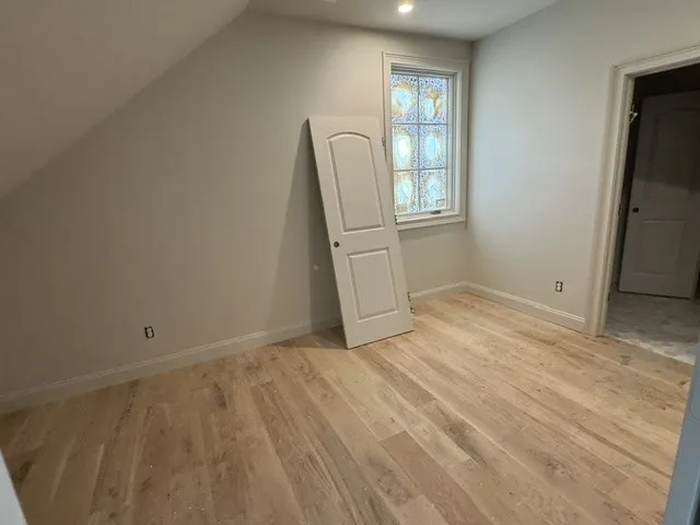 A sloped ceiling and warm wood flooring define this versatile upper-level space.