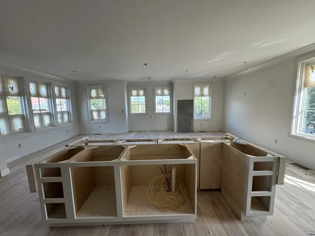 Natural light pours across the open layout highlighting the hardwood flooring and extensive window design.