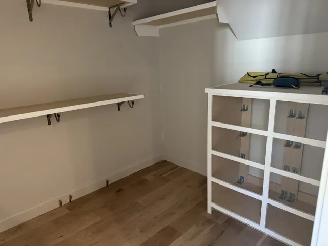 Ample built-in shelving and rich wood flooring maximize organization in this storage space.