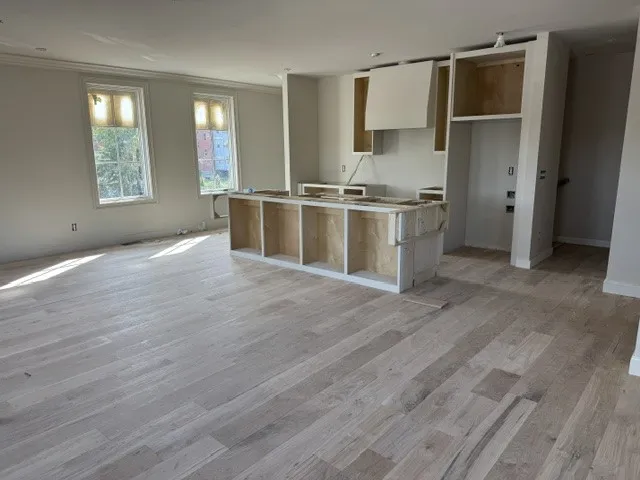 Gleaming hardwood floors flow throughout this airy, open-concept kitchen and living area.