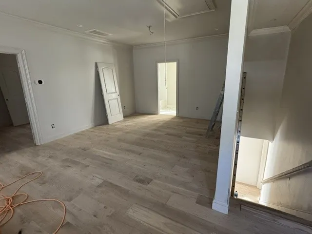 Crisp crown molding and smooth wood floors define this versatile, light-filled upper-level space.