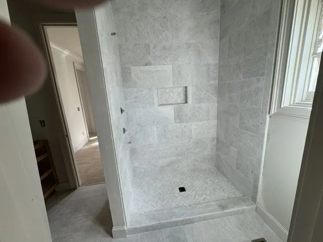 Elegant tile work highlights this spacious walk-in shower area.