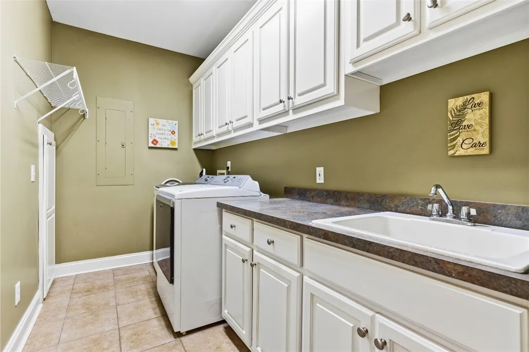 The laundry room has  abundant storage and a convenient utility sink.