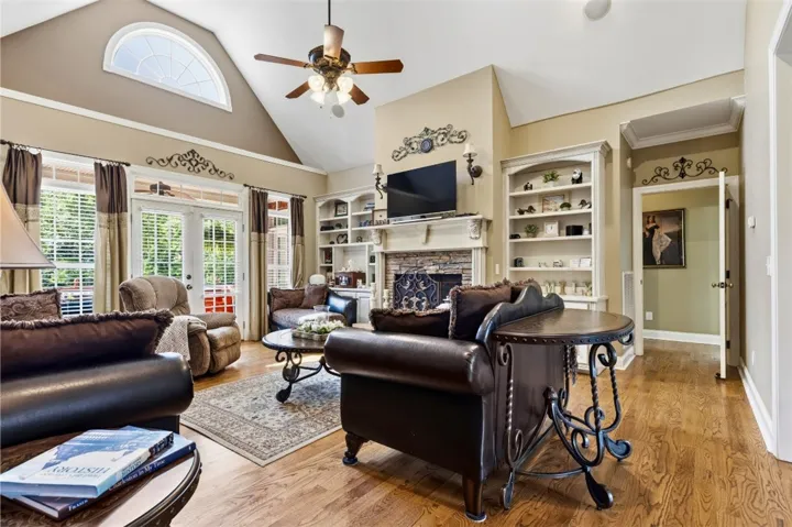 The great room has vaulted ceilings, built-in shelving, and a cozy gas log fireplace, perfect for gatherings.