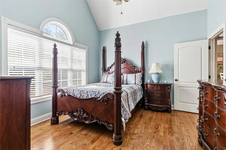 Bedroom 2 is spacious with  elegant wood flooring, a beautiful arched window and lots of natural light.