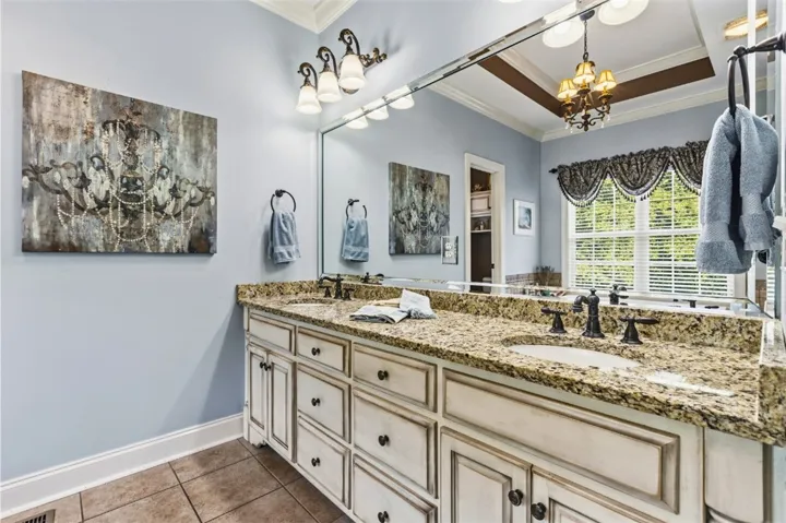 The primary bathroom has a double vanity with granite counter.