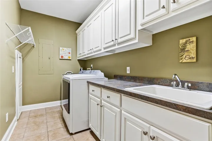 The laundry room has  abundant storage and a convenient utility sink.
