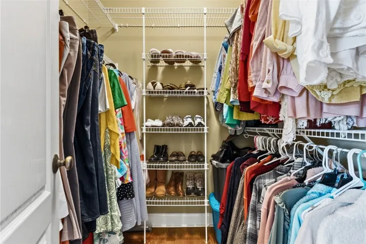 This walk-in closet offers efficient storage with shelving and hanging space for an expansive wardrobe. There is another one just like it.