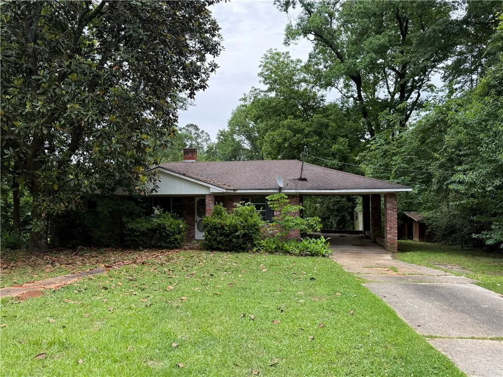 This charming residence features a classic brick exterior and a welcoming carport.