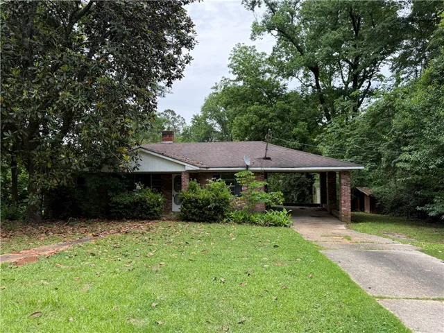 This charming residence features a classic brick exterior and a welcoming carport.