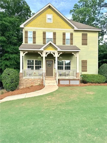 This charming residence features a welcoming porch and well-maintained landscaping, perfect for comfortable living.