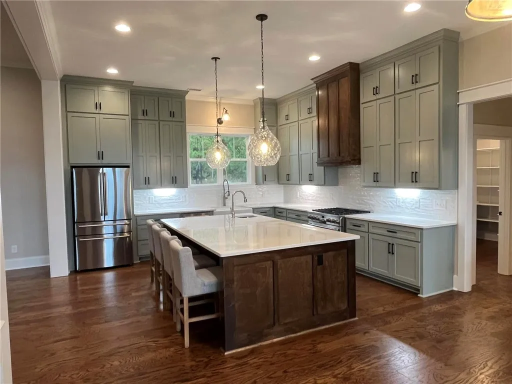 *EXAMPLE OF FINISHED PRODUCT* This spacious kitchen offers a large island, generous counter space, and warm wood flooring.