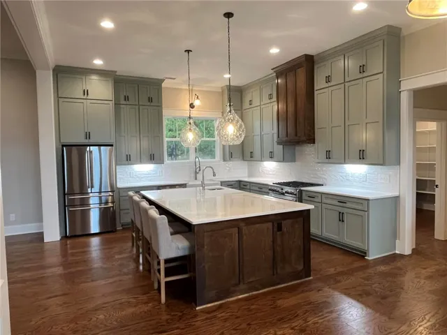 *EXAMPLE OF FINISHED PRODUCT* This spacious kitchen offers a large island, generous counter space, and warm wood flooring.