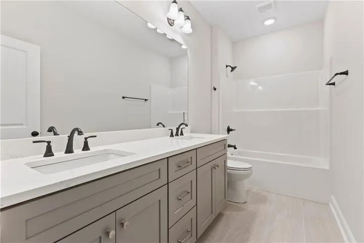 Modern bath features a double vanity and sleek fixtures, perfect for daily routines.