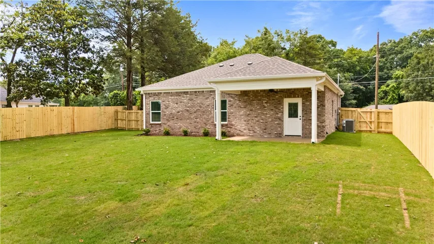 A private, fenced backyard offers a verdant lawn perfect for outdoor enjoyment.