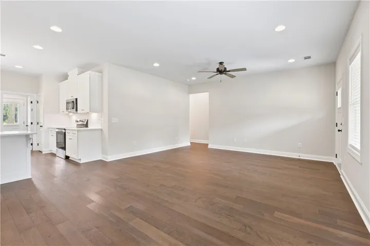 An open-concept living area with gleaming hardwood floors flows seamlessly into a contemporary kitchen.