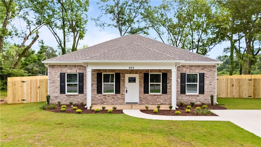 A welcoming front porch enhances this charming New Build brick home amidst the lush green grass landscaping.
