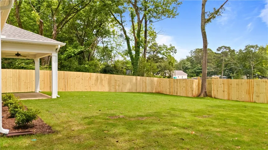 A spacious, verdant yard with a new wood privacy fence.
