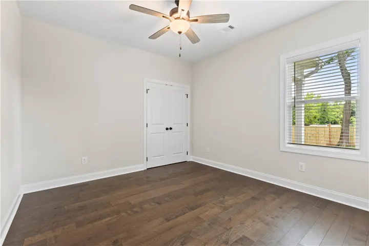 Hardwood floors and a ceiling fan create a comfortable and inviting atmosphere in this bedroom or flexible space.