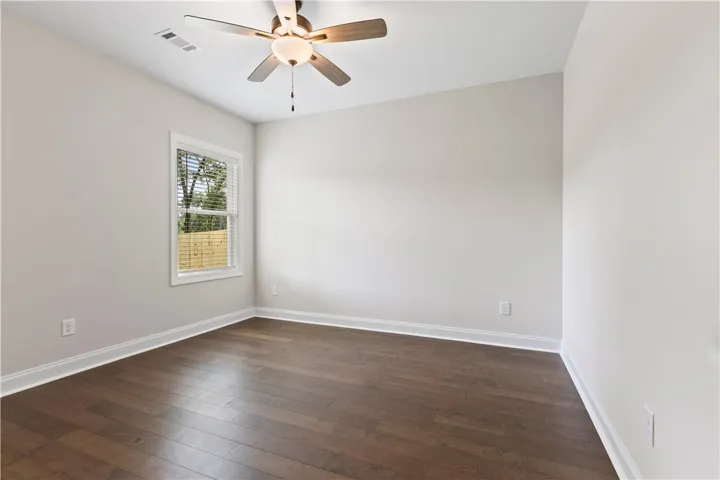 Rich hardwood floors complement this spacious bedroom, ready for personalization.