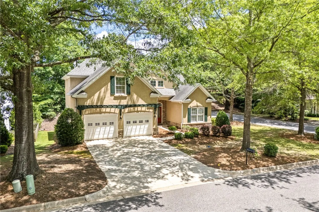 This beautiful residence features a welcoming exterior, an attached garage, and a spacious driveway.