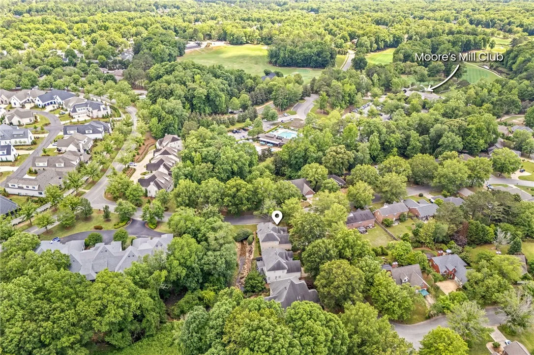 An aerial perspective reveals a vibrant neighborhood nestled among lush trees and community amenities.