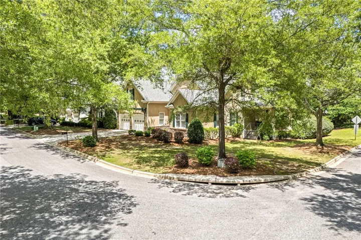 This residence showcases a traditional facade framed by mature trees, offering privacy and charm.