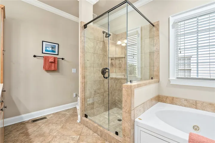 This bathroom features a sleek glass shower and a large soaking tub, creating a serene personal retreat.
