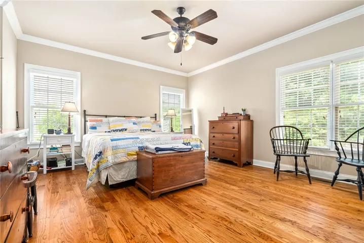 This airy bedroom features gleaming hardwood floors and large windows, creating a bright and inviting retreat.