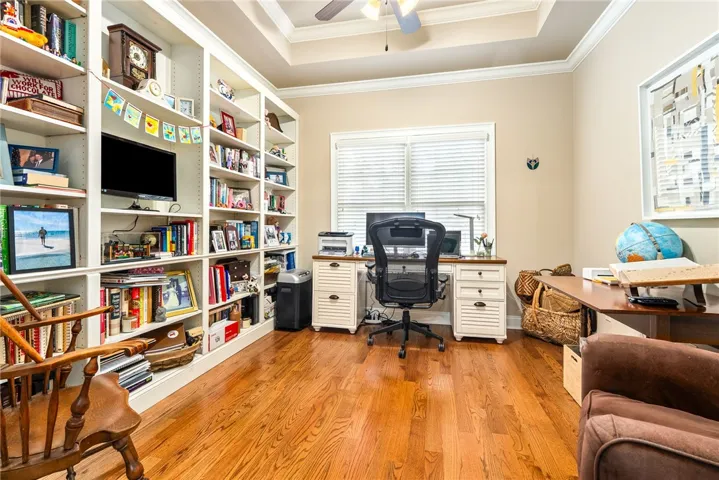 This dedicated workspace offers rich wood flooring and ample built-in storage, perfect for productivity.