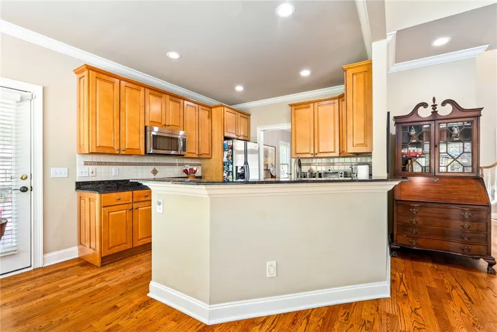 This inviting kitchen offers ample cabinetry, modern appliances, and beautiful hardwood flooring.